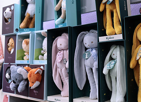 Primer plano de una estantería dónde podemos ver peluches para bebé, que representan a distintos animales. Si se repite el animal, este cambia de color