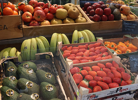 Primer plano de un expositor con cajas de frutas de temporada