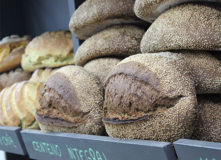 Primer plano de una estantería en la que se pueden ver hogazas de pan de centeno