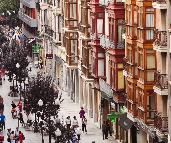 Vista de la calle Corrida, en su zona peatonal, tomada desde un piso alto. En la calle se ven varios grupos de personas así como los árboles y farolas que dividen la calle longitudinalmente