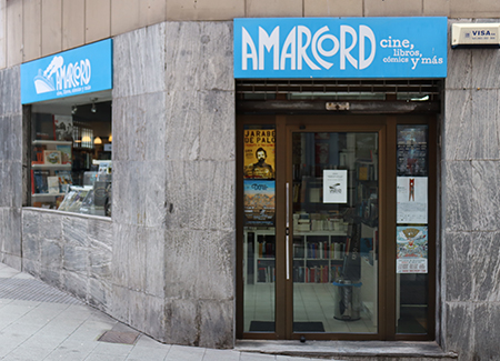 Vista exterior de la librería, dónde vemos la entrada haciendo esquina y un escaparate que da a una de las calles