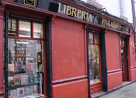 Vista exterior de la librería, dónde vemos la puerta al fondo y dos escaparates