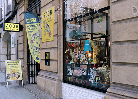 vista exterior de la tienda, dónde se puede ver la entrada con los carteles que anuncian la tienda y el escaparate